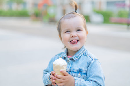 happy baby girl holding ice cream in waffle cone, love ice cream