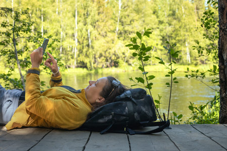 a female traveler rests during a camping stop on a hike, Freedom and active lifestyle concept, local...