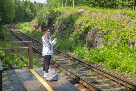 Budget Travel, young woman waiting for local train at rural railway stationの写真素材