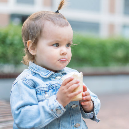 A happy fun cute child eats ice cream on a hot day in park. Ice cream in a waffle cone.の写真素材