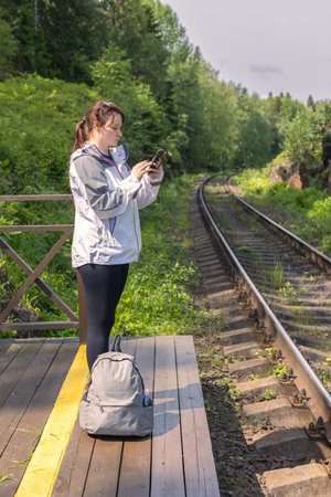 young woman at local train station, train schedule, budget travelの写真素材