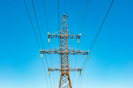 Electricity power pole with transmission lines against blue skyの写真素材