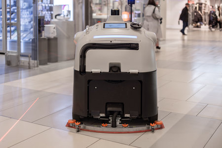A large robot vacuum cleaner self driving cleaning a shopping mallの写真素材