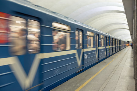 A high-speed train moves through an underground metro station. A modern passenger car with motion blur effects on a railway platformの写真素材
