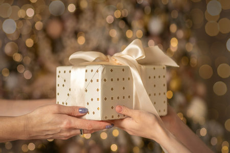 Gift box in the hands of mother and daughter, Christmas mood.