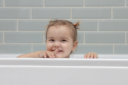 Happy baby girl taking a bubble bath