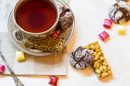 A cup of tea, cookies and sweets on the cloth.の写真素材