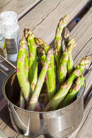 Fresh green asparagus in a pan on an old table.の写真素材