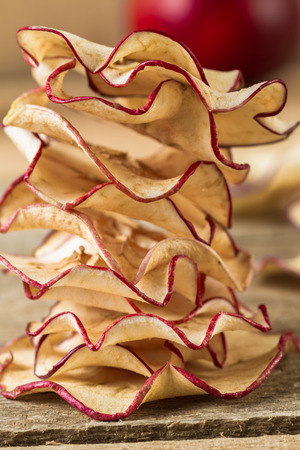 Homemade dehydrated apple chips on a wooden table.の写真素材