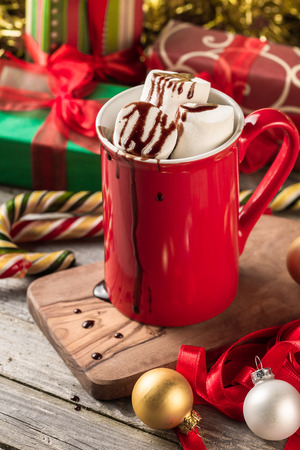 Christmas red mug of hot cocoa garnished with marshmallows and chocolate.の写真素材