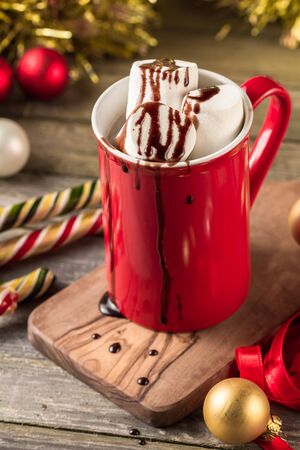Christmas red mug of hot cocoa garnished with marshmallows and chocolate.の写真素材