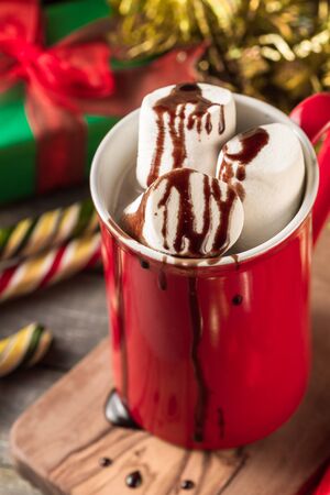 Christmas red mug of hot cocoa garnished with marshmallows and chocolate.の写真素材