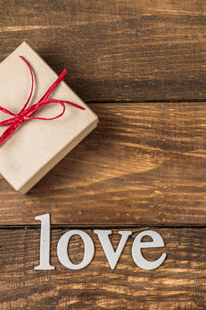 Gift for Valentine's Day and the word "love" on a wooden background.の写真素材