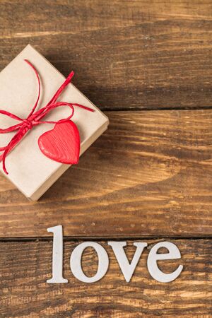 Gift for Valentine's Day and the word "love" on a wooden background.の写真素材