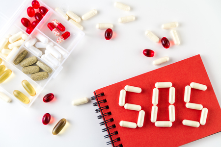 Various medical capsules, pills and word "SOS".の写真素材