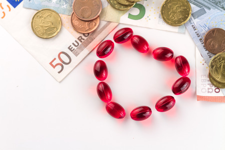 Medical capsules, money and coins on a white background.の写真素材