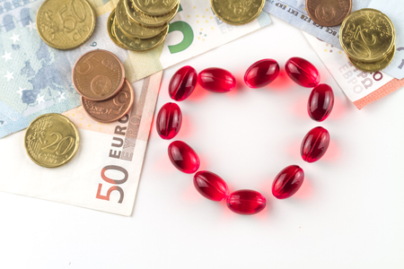 Medical capsules, money and coins on a white background.の写真素材