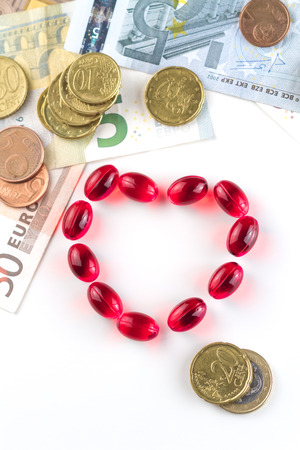 Medical capsules, money and coins on a white background.の写真素材