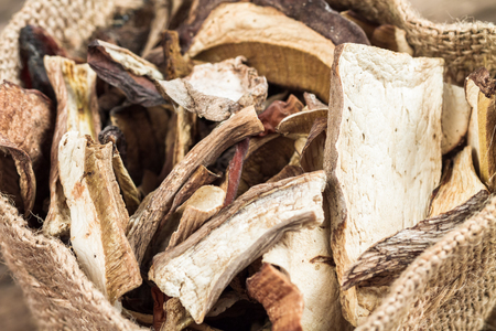 Wild edible dehydrated mushrooms on an old wooden background.の写真素材