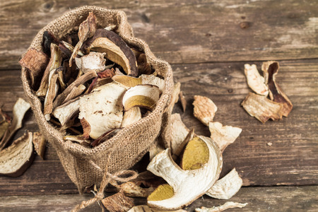 Wild edible dehydrated mushrooms on an old wooden background.の写真素材