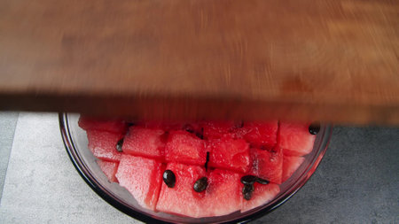 Watermelon slices, a cut piece of watermelon placed in a transparent glass bowlの写真素材