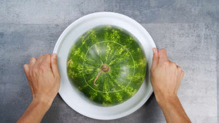 Red watermelon, cut into square slices, laid out on a plate on a white backgroundの写真素材