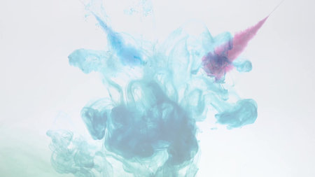An explosion of colored paints in water on a white background
