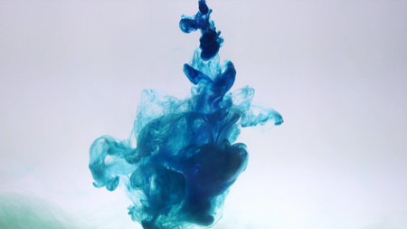 An explosion of colored paints in water on a white backgroundの写真素材