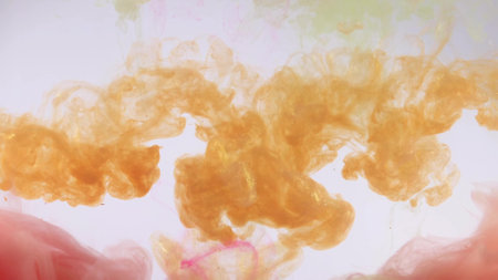 An explosion of colored paints in water on a white backgroundの写真素材