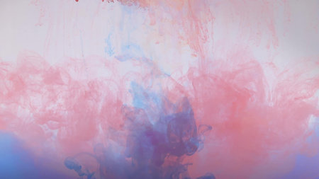 An explosion of colored paints in water on a white background.