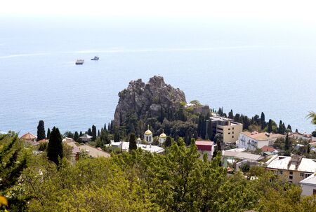 Gurzuf, Crimea - September 7, 2016: Rocky Beach with a protruding rock domes of churches and residential buildings located among different vegetation. Rock of Chaliapin, Church of the Assumption of the Blessed Virgin look with Bolgatura Mountains in Gurzuの写真素材