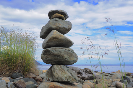 The stones, stacked in a tower on the shore of lake Baikalの写真素材