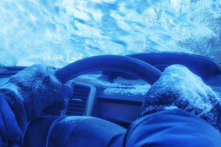 driver's hands in gloves in a frozen carの写真素材