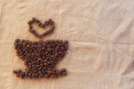 image of Cup and heart of coffee beans on fabric.の写真素材