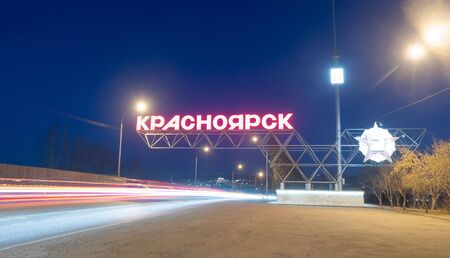 Krasnoyarsk, Russia - April 09, 2019 :sign at the entrance to the city of Krasnoyarsk, car traffic at night.のeditorial素材