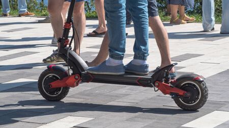 a young man riding an electric scooter in the Park on a summer dayの写真素材