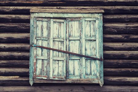 window with shutters in an old wooden house, historic building.の写真素材