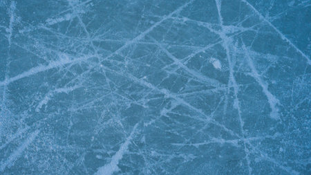 ice background with marks from skating and hockey, blue texture.