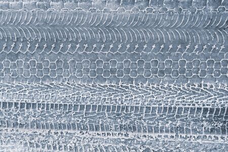 car tire tracks on a snowy road, background.の写真素材