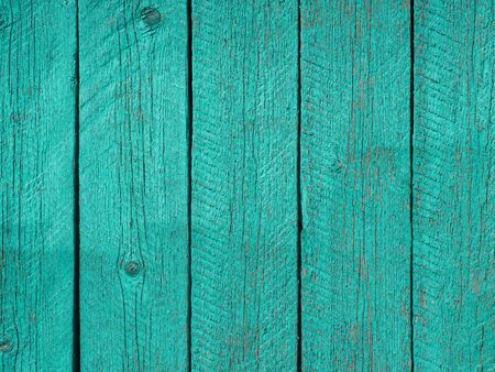 Wooden fence painted in green, peeling cracked paint.の写真素材