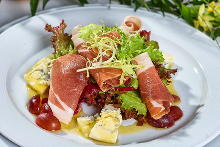 meat salad with ham cheese lettuce Dorblu grapes and olive oilの写真素材