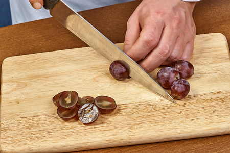 Chef sliced grapes on a cutting board Chefs hands Close-upの写真素材