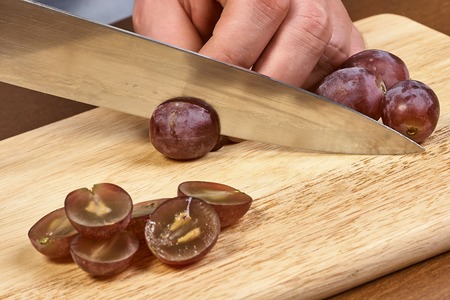 Chef sliced grapes on a cutting board Chefs hands Close-upの写真素材