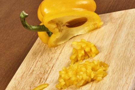 closeup on hands cutting yellow pepper on professional kitchenの写真素材