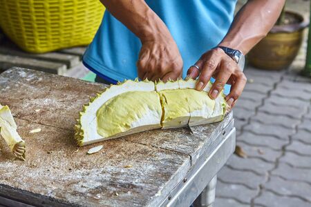 man cleans the market of exotic fruit durian in Thailandの写真素材