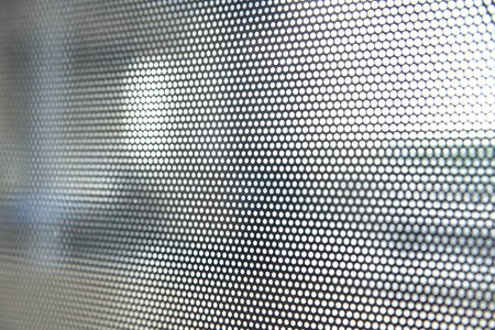 Black toning mesh on glass with small holes in the airport. Selective focus.  Closeup abstract dot...