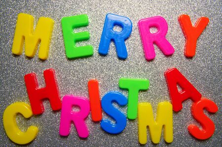 Merry cristmas. Written in a colorful plastic letters on a shiny silver background.  Inscription merry christmas from colour plastic letters. Letters for teaching children the English alphabet.の写真素材