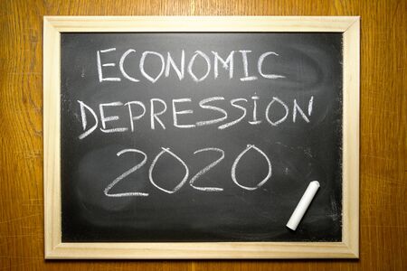 ECONOMIC DEPRESSION 2020 text  on black chalk board. White chalk in the corner. Concept of declines in financial markets caused by the virus in 2020 on the planet.の写真素材