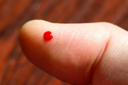 Finger with blood to make glucose level blood test.