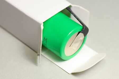 New green rechargeable lithium ion battery type 18650 inside white paper cardboard box.の写真素材